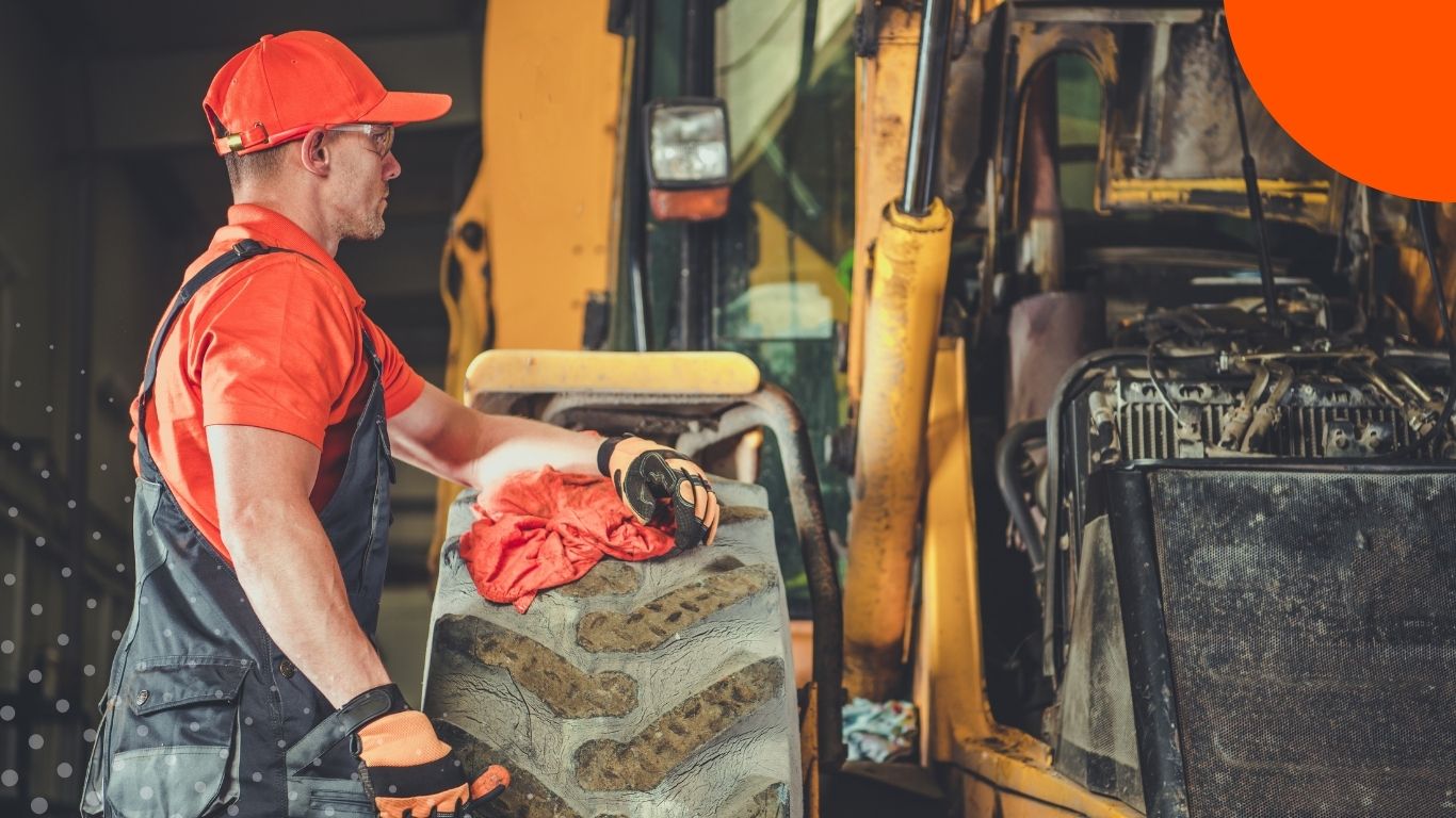 A technician inspecting agricultural equipment in a service workshop